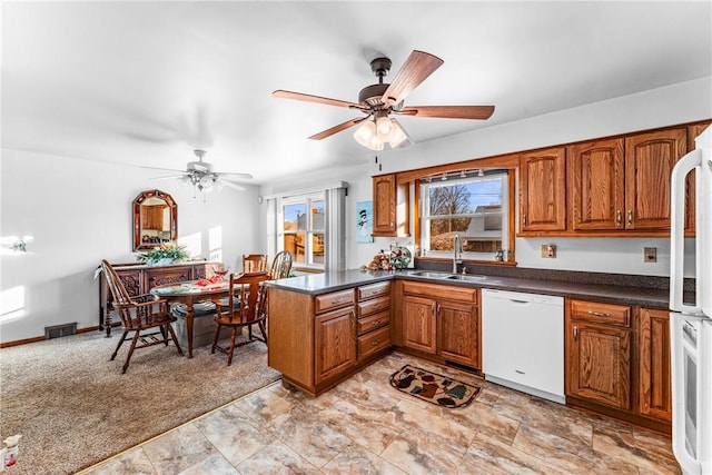 kitchen featuring sink, white appliances, ceiling fan, light carpet, and kitchen peninsula