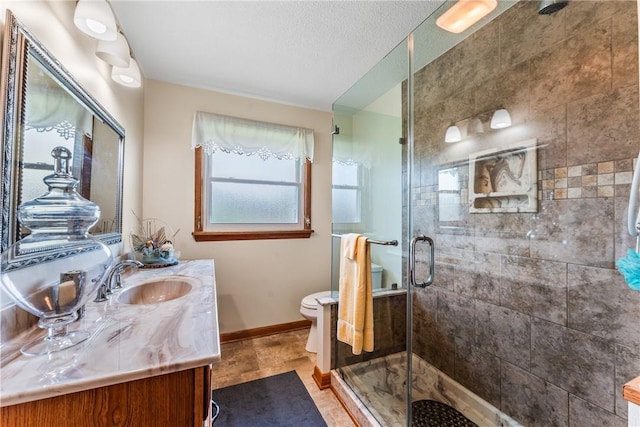 bathroom with vanity, a textured ceiling, toilet, and walk in shower