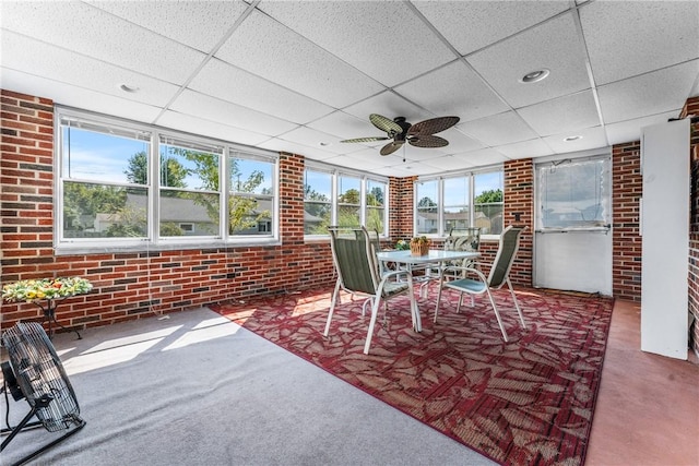 unfurnished sunroom with a paneled ceiling and ceiling fan