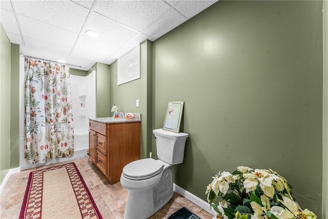 full bathroom with vanity, a paneled ceiling, shower / bath combo with shower curtain, and toilet