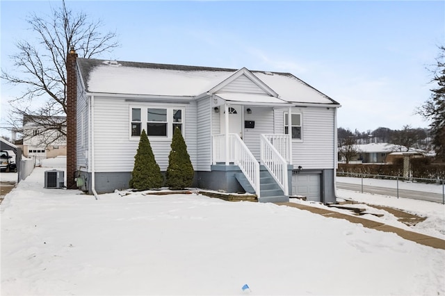 view of front of property with a garage and central AC unit