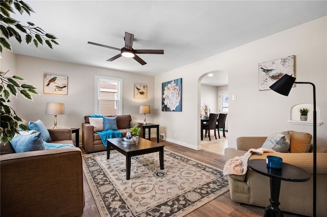 living room featuring wood-type flooring and ceiling fan