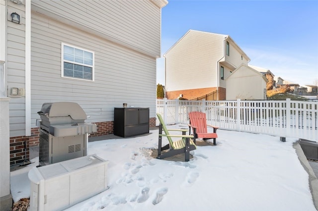 snow covered patio featuring a grill