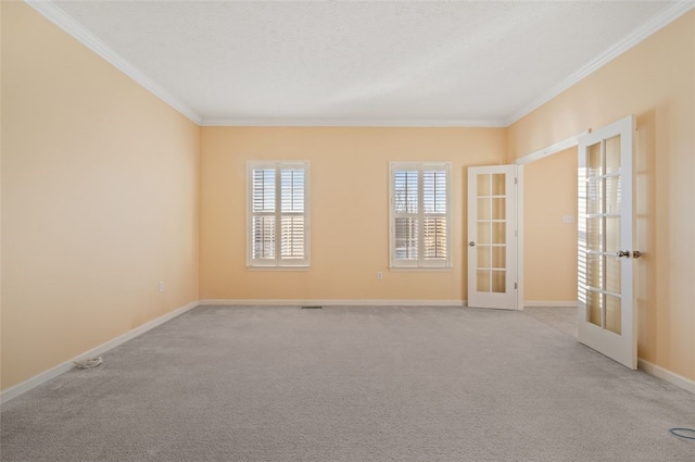 carpeted spare room featuring crown molding and french doors