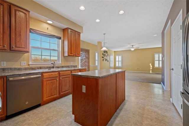 kitchen featuring sink, hanging light fixtures, a wealth of natural light, a kitchen island, and stainless steel dishwasher