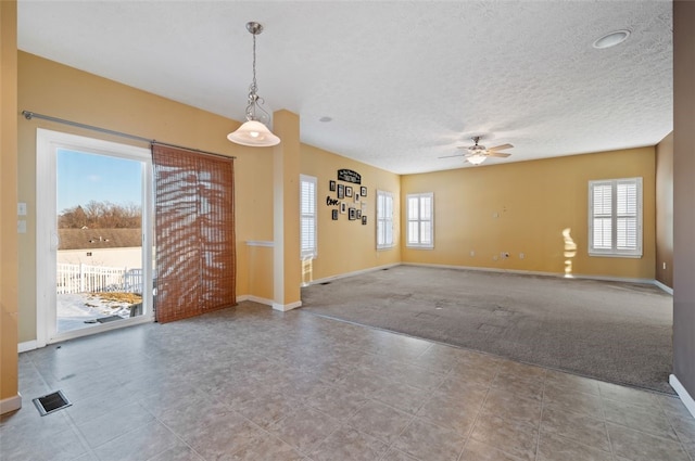 interior space with a textured ceiling and ceiling fan