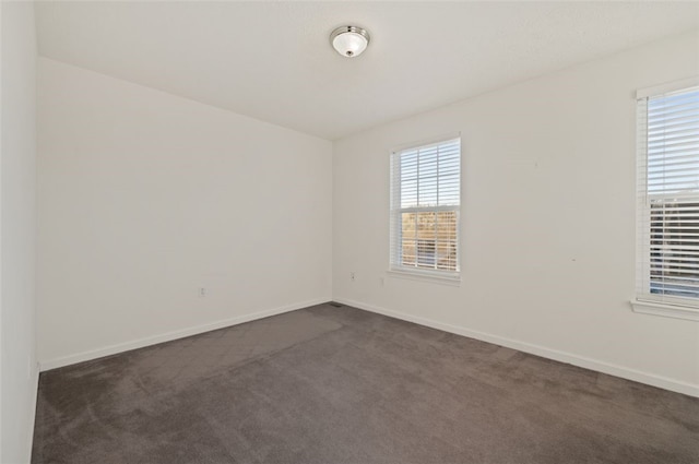 empty room with dark colored carpet