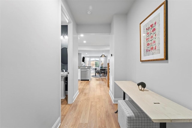 hallway with light wood finished floors and baseboards