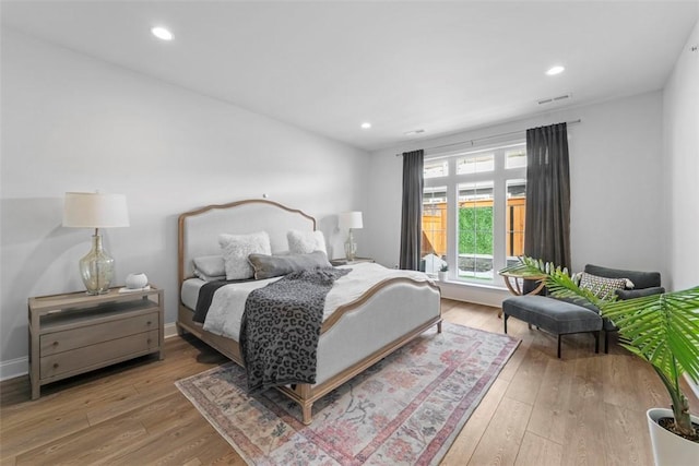 bedroom featuring wood finished floors, visible vents, and recessed lighting