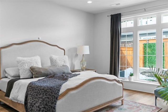 bedroom featuring wood finished floors, visible vents, and recessed lighting