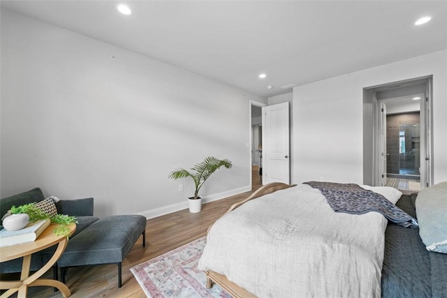 bedroom with recessed lighting, wood finished floors, and baseboards