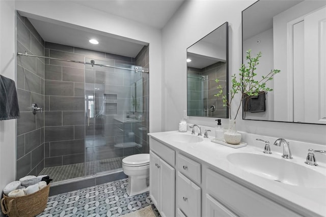 full bath with a sink, a shower stall, toilet, and double vanity