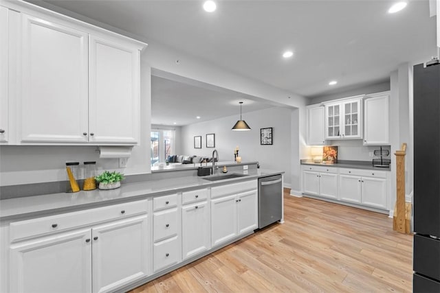 kitchen with pendant lighting, glass insert cabinets, white cabinetry, a sink, and dishwasher