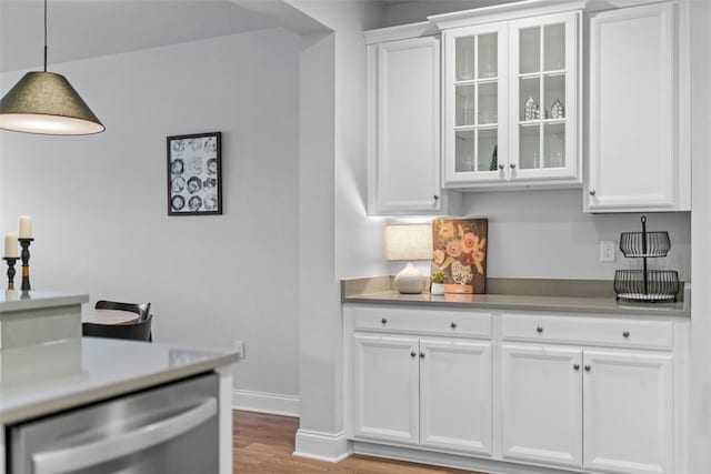 interior space featuring light wood finished floors, baseboards, pendant lighting, and dishwasher