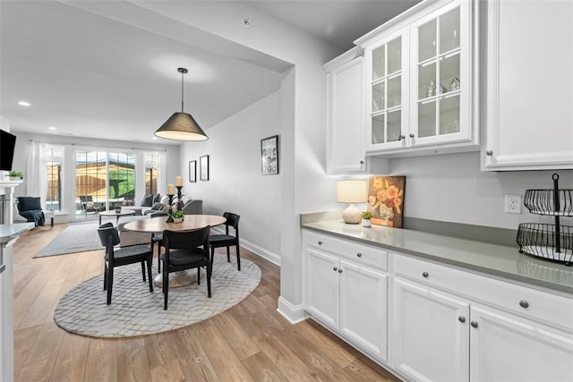 dining space with recessed lighting, light wood-style flooring, and baseboards