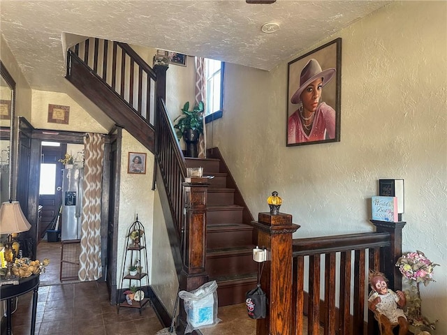 staircase with plenty of natural light and a textured ceiling