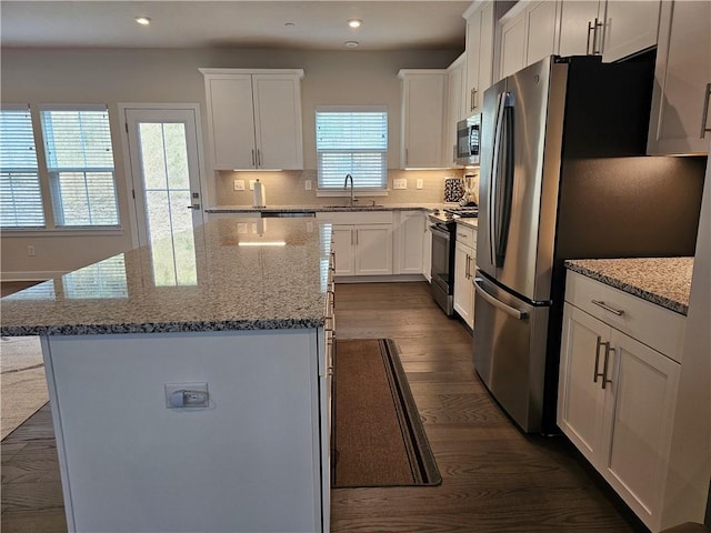 kitchen featuring sink, stainless steel appliances, white cabinets, and a kitchen island