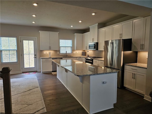 kitchen featuring appliances with stainless steel finishes, a center island, stone countertops, and white cabinets