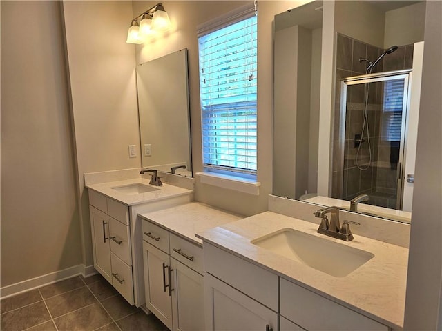 bathroom featuring tile patterned flooring, vanity, a healthy amount of sunlight, and a shower with shower door