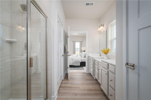 bathroom featuring a shower with door, wood-type flooring, and vanity