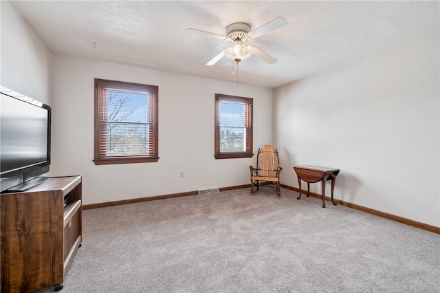 sitting room featuring a wealth of natural light, light colored carpet, and ceiling fan