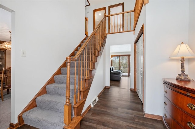 stairs with an inviting chandelier and hardwood / wood-style floors