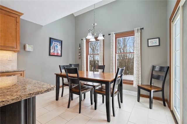 dining area with light tile patterned flooring and a chandelier