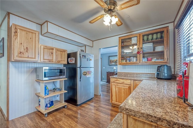 kitchen featuring dark hardwood / wood-style flooring, ornamental molding, light brown cabinets, and appliances with stainless steel finishes