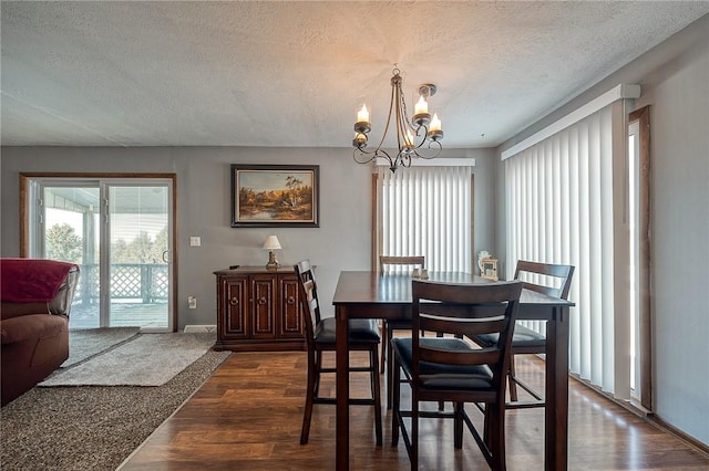 dining room with an inviting chandelier, dark wood-type flooring, and a textured ceiling