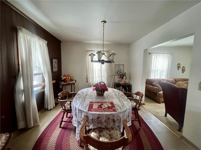 carpeted dining space with a chandelier