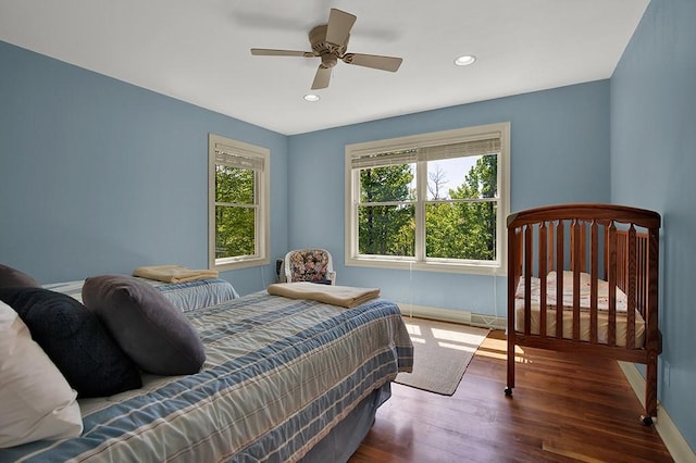 bedroom with dark hardwood / wood-style flooring and ceiling fan