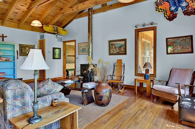 living room featuring light wood-type flooring, wooden ceiling, lofted ceiling with beams, and a wood stove