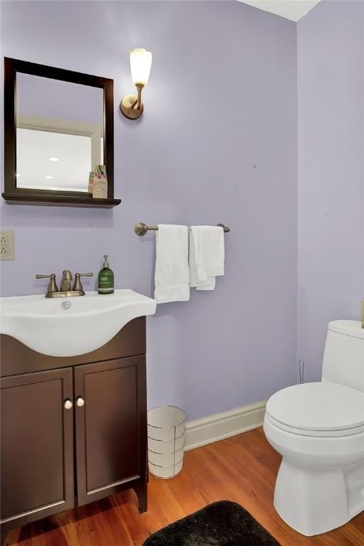 bathroom with vanity, wood-type flooring, and toilet