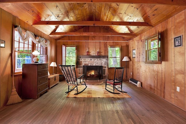 sitting room with hardwood / wood-style flooring, a stone fireplace, vaulted ceiling with beams, and wood ceiling