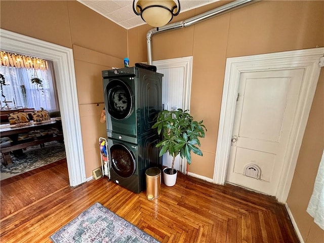 clothes washing area featuring stacked washing maching and dryer