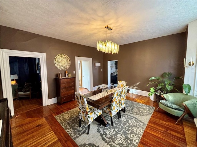 dining space with dark hardwood / wood-style floors, a chandelier, and a textured ceiling