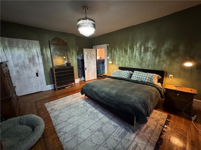 bedroom featuring wood-type flooring and a notable chandelier