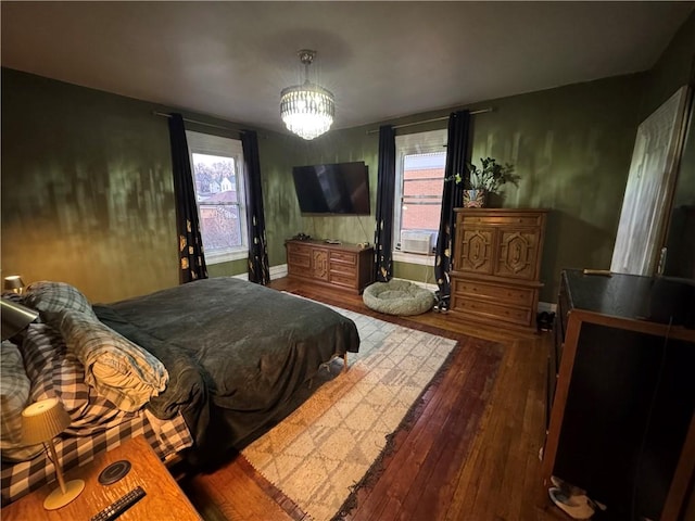 bedroom featuring cooling unit, dark hardwood / wood-style flooring, multiple windows, and a notable chandelier