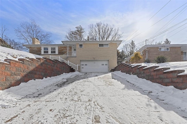 snow covered property featuring a garage