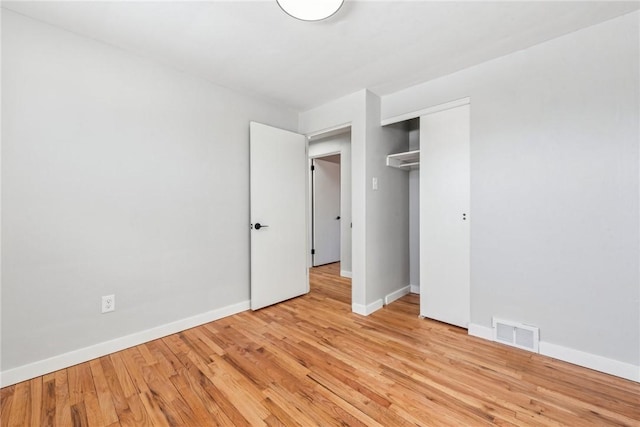 unfurnished bedroom with light hardwood / wood-style flooring and a closet