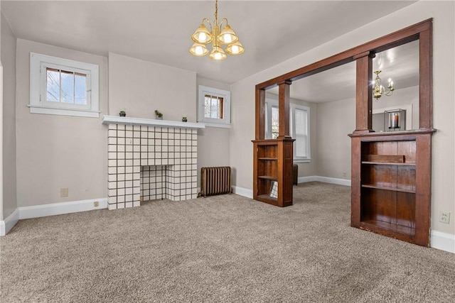 unfurnished living room featuring a healthy amount of sunlight, radiator heating unit, a fireplace, and carpet flooring