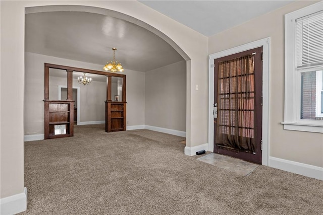 entrance foyer with carpet flooring and a chandelier