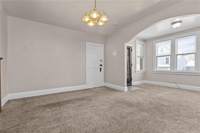 empty room featuring a chandelier and carpet