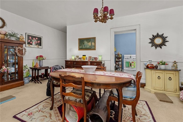 dining room featuring light carpet and an inviting chandelier