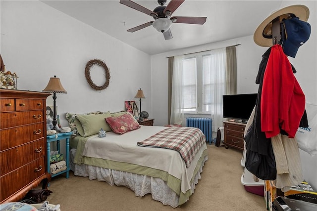 bedroom with ceiling fan, radiator heating unit, and light carpet