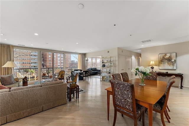 dining area featuring expansive windows and light wood-type flooring