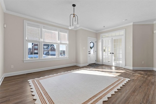 foyer featuring dark hardwood / wood-style flooring, ornamental molding, and french doors