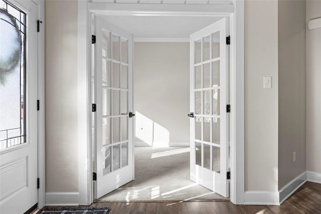 doorway to outside with french doors, crown molding, and dark wood-type flooring