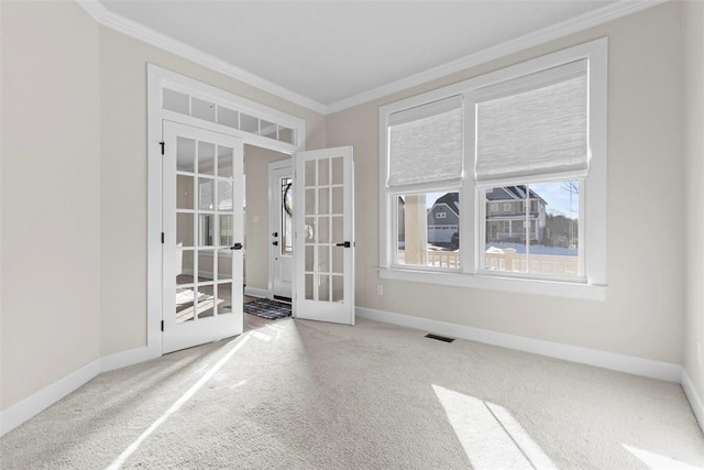 spare room with ornamental molding, french doors, and carpet