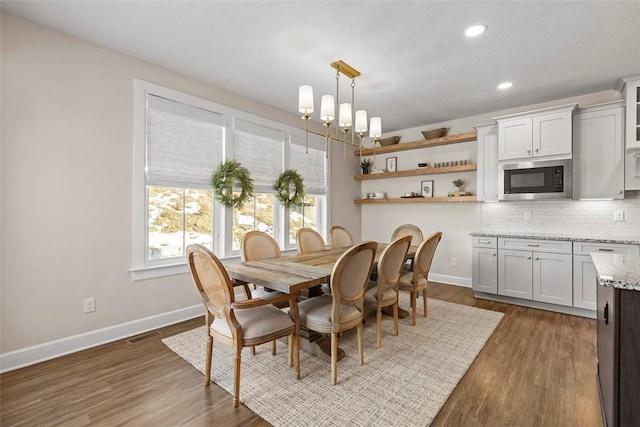 dining room featuring dark hardwood / wood-style flooring and an inviting chandelier